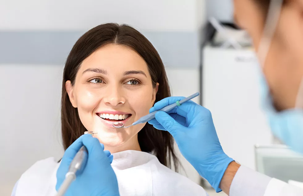 Zahnarzt führt Prophylaxe an einer weiblichen Patientin durch